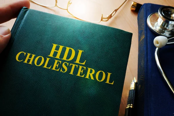 Mann mit Buch über Hdl-Cholesterin. — Stockfoto