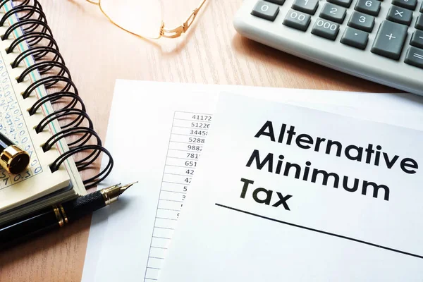 Alternatieve Minimum belasting (Amt) en Rekenmachine op een bureau. — Stockfoto