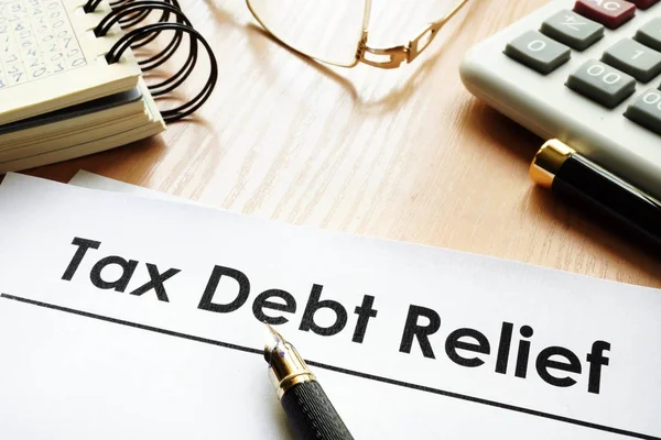 Documenti con la riduzione del debito fiscale titolo su una scrivania . — Foto Stock
