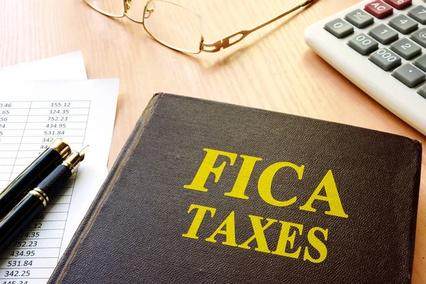 FICA Taxes et calculatrice sur une table . — Photo