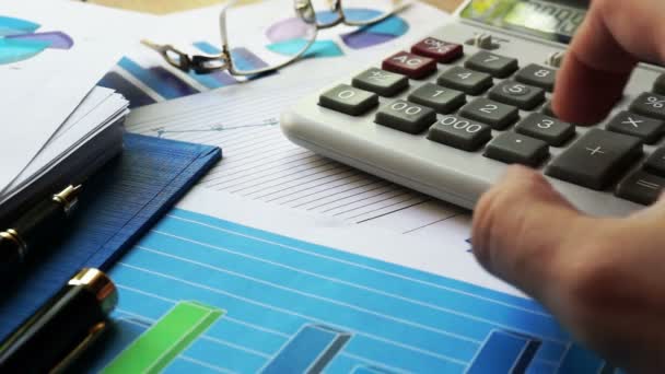 Hombre usando calculadora para calcular en un escritorio de oficina . — Vídeo de stock