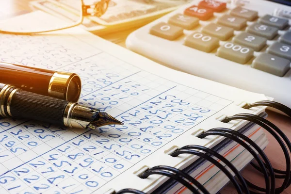 Dati aziendali in un libro contabile e in una calcolatrice . — Foto Stock