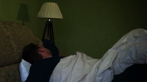 Man wakker op een nacht voor het lezen van berichten in een smartphone. — Stockvideo