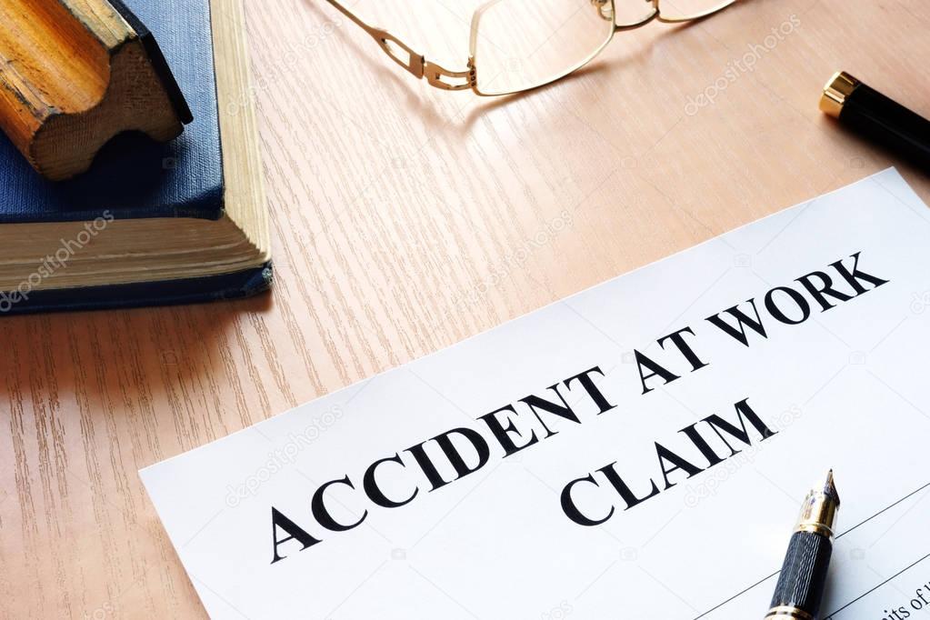 Accident at work claim and glasses on a table.