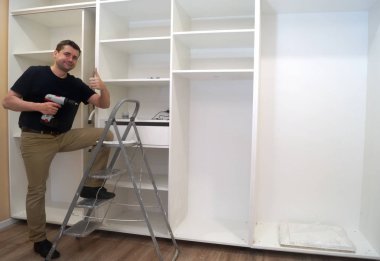 Yerleşik wardro montaj esnasında gülümseyen hizmet adam