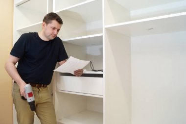 Dolap montaj. Adam bi dolap yükleme bir tornavida ile.