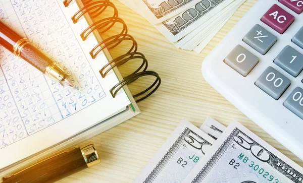 Small business accounting. Ledger, pen, money and calculator. — Stock Photo, Image