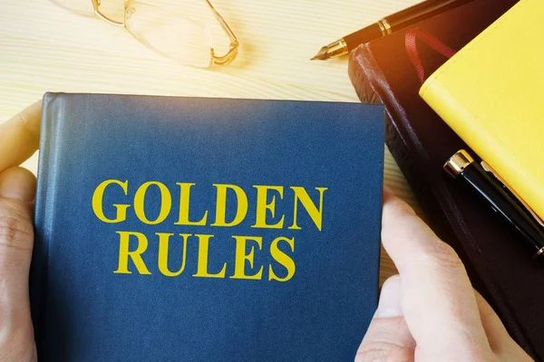 Mann mit Führer mit Titel Goldene Regeln. — Stockfoto