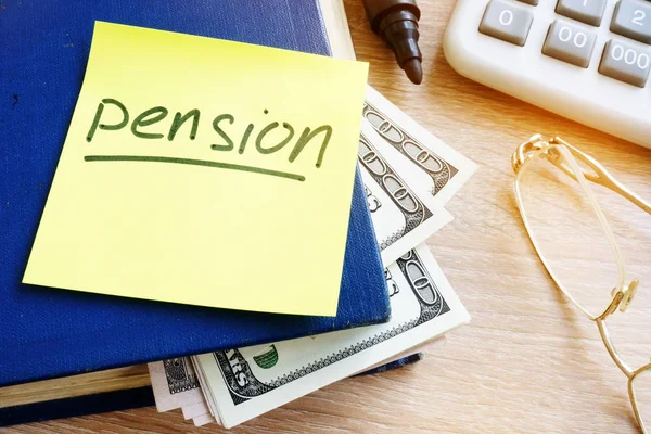 Pension som skrivit på en pinne och pengar i boken. Pensionssparande. — Stockfoto