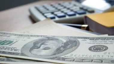 Bir Ofis Masası götünde para. Bize dolar faturaları ve hesap makinesi. Finans ve tasarruf kavramı.