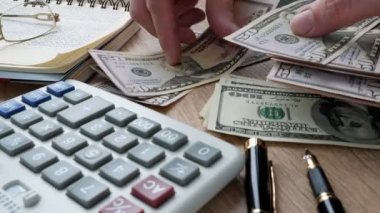 Adam bir ofis masasında para sayma. Para ve hesap makinesi. Tasarruf ve ev bütçe.