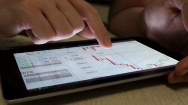 Online Ticaret. Finansal piyasa hisse senedi bilgilerini kontrol etmek için tablet kullanan adam. 
