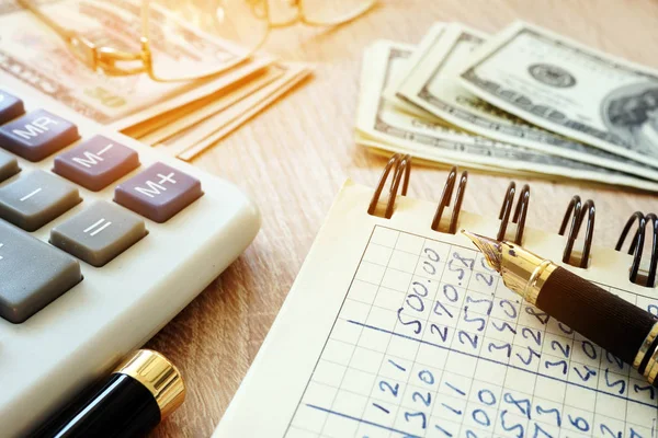 Pénz, számológép, toll és számviteli könyv egy íróasztal. — Stock Fotó