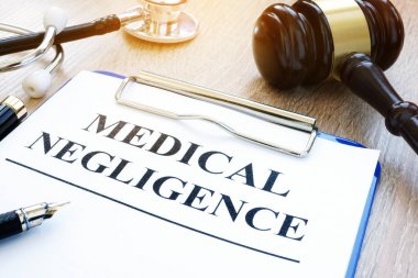 Clipboard with documents about medical negligence on a table. clipart