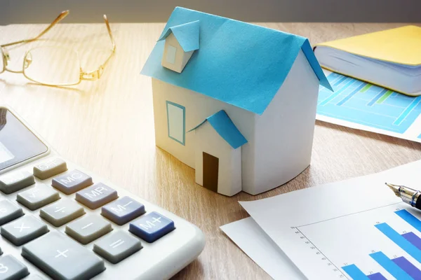 Propiedad invertir concepto. Modelo de casa e información financiera sobre el mercado inmobiliario . —  Fotos de Stock
