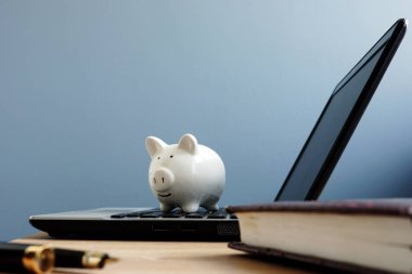 Bir dizüstü bilgisayarda kumbara. Online tasarruf veya bankacılık kavramı.