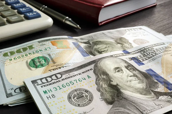 Personal finances. Stack of money and calculator on the desk.