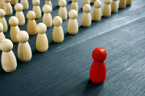 Concetto di leadership management. Figura rossa come leader di fronte a figure di legno . — Foto Stock