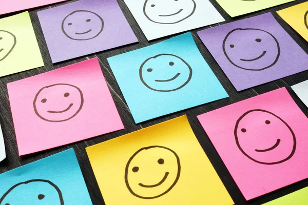 Uśmiechnięte szczęśliwe twarze narysowane na prześcieradłach. Doświadczenie klienta i koncepcja oceny. — Zdjęcie stockowe