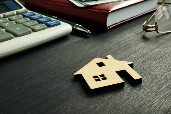 Modelo de casa en el escritorio. Valor de la propiedad y concepto de hipoteca . —  Fotos de Stock