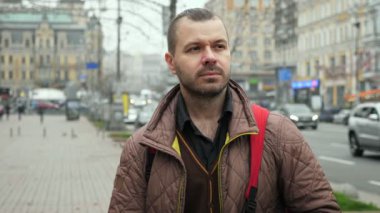 Sakallı adamın portresi. Bulutlu sonbahar şehri sokağı.