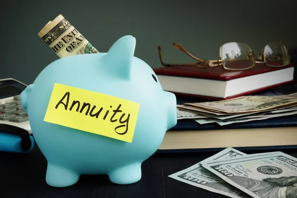 Annuity written on yellow sheet and piggy bank with money. — Stock Photo, Image