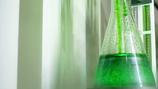 実験室での実験のための緑色の化学液体を用いた試験管としての化学装置 — ストック動画