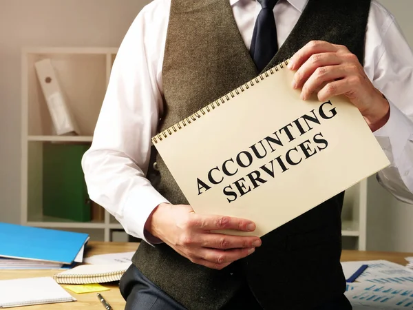 Accounting services sign in the hands of accountant.