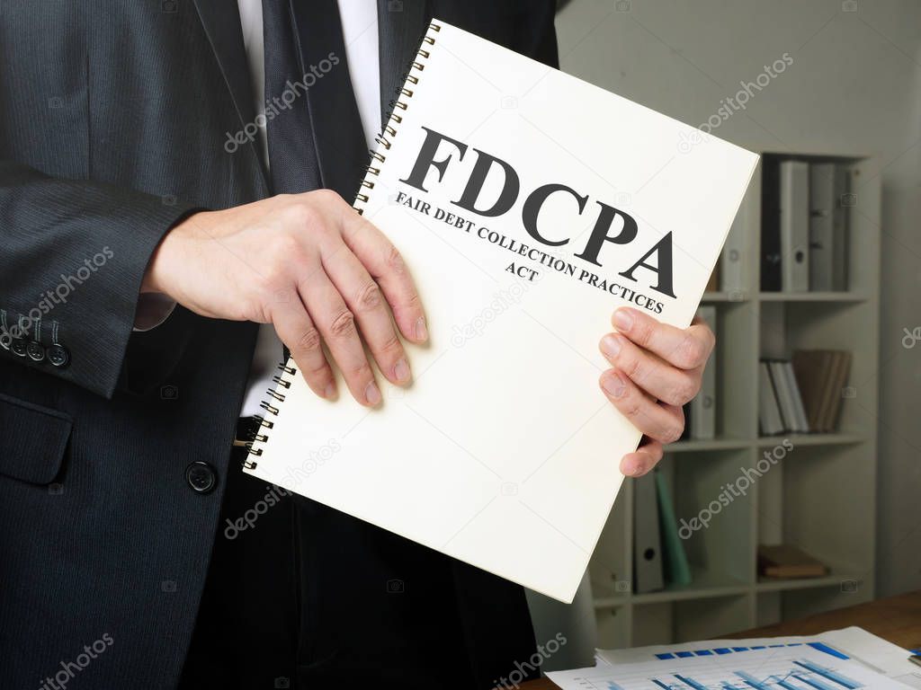Man holds The Fair Debt Collection Practices Act FDCPA.