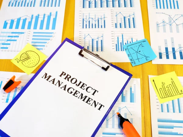 Project management plan and business report on the desk.