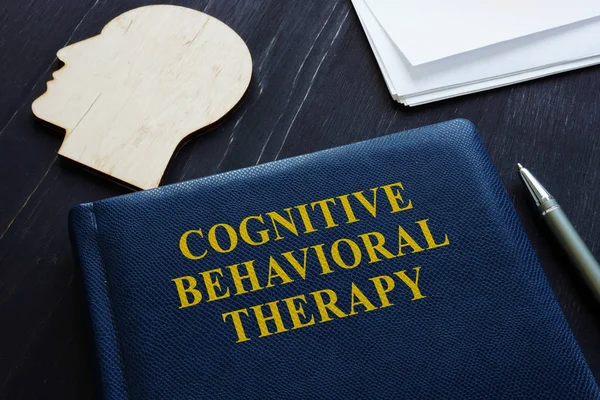 Kognitive Verhaltenstherapie cbt Buch und Holzkopfform. — Stockfoto