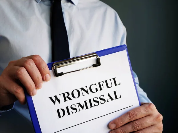 Man holds papers about Wrongful dismissal. — Stock Photo, Image
