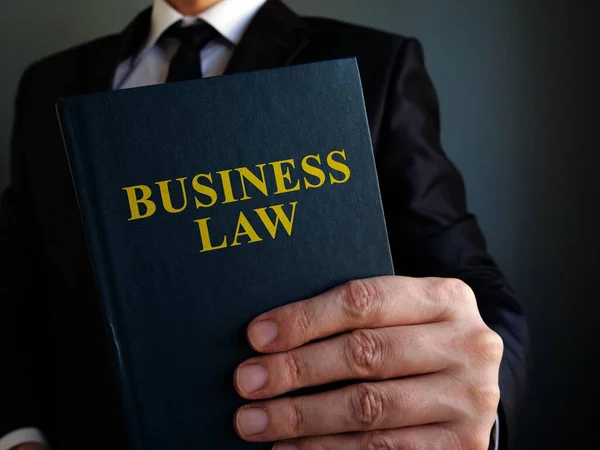 Empresário está segurando livro de direito empresarial . — Fotografia de Stock
