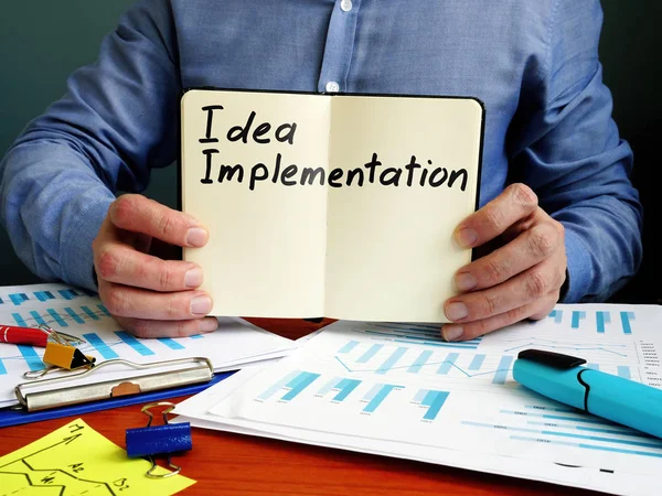 Idea Plan de implementación en el bloc de notas pequeño . — Foto de Stock