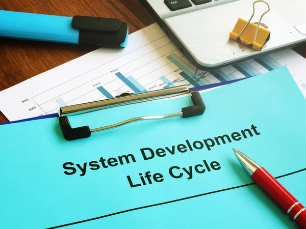 System Development Life Cycle SDLC papers and clipboard.