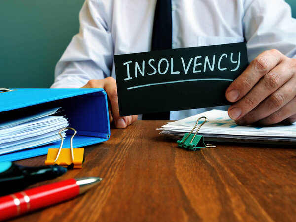 Man holds sign insolvency about company bankruptcy.