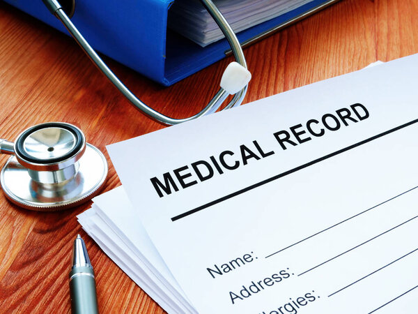Medical record and stack of papers with stethoscope.