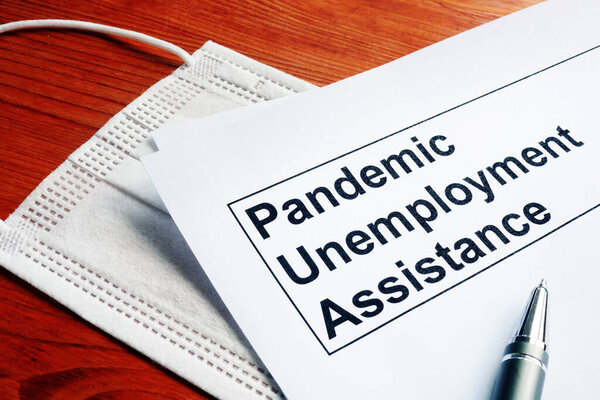 Pandemic Unemployment Assistance PUA papers and medical mask.