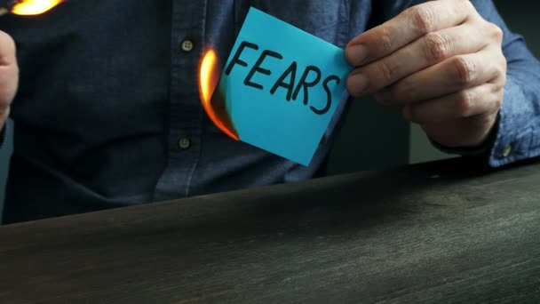 A man burns a sheet with the words fears. Motivational concept video about mental problems. — Stock Video