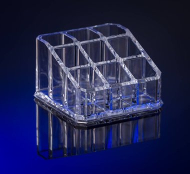 Kare şeklindeki boş makyaj ruju tutucusu. Saf mavi arkaplanda ayna yansıması var.