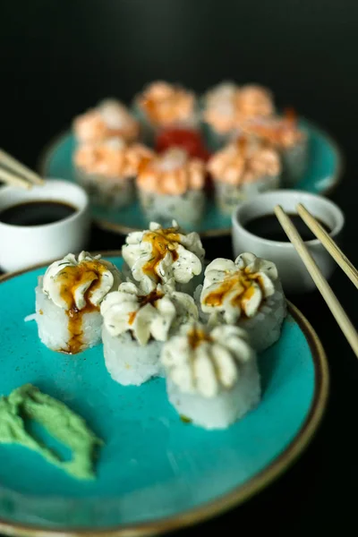Суши в голубой тарелке, палочки для еды и соевый соус — стоковое фото