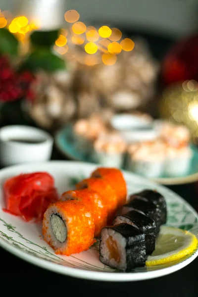 Różne rodzaje sushi serwowane na czarny stół — Zdjęcie stockowe