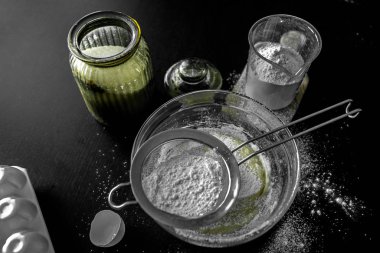 Ev yapımı için malzemeler: kurabiye, ekmek, pasta. Un, şeker ve yumurtalar siyah masada. Fırın yemekleri..