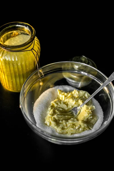 Yumuşak tereyağlı ve şekerli bardakta, çatalla karıştırılmış. Kurabiye, pasta ve kek için hamur hazırlığı. Siyah bir masa ve bir kavanoz şeker..