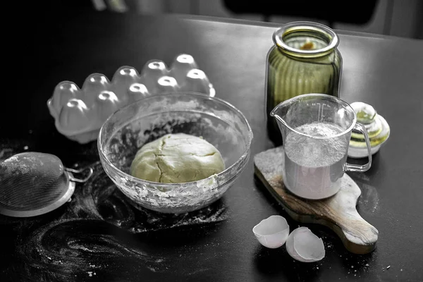 Ingredientes para hornear en casa: galletas, pan, pastel. Harina, azúcar y huevos están en la mesa negra. Platos para hornear . —  Fotos de Stock