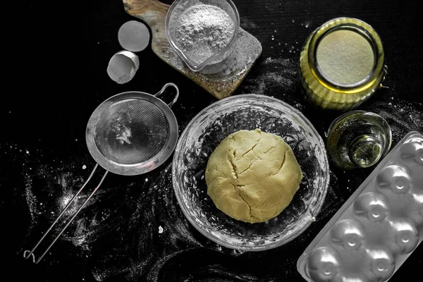 Ingredientes para hornear en casa: galletas, pan, pastel. Harina, azúcar y huevos están en la mesa negra. Platos para hornear . —  Fotos de Stock