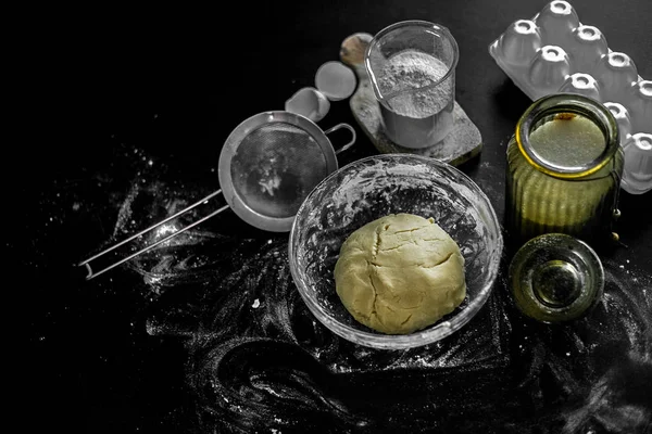 Ingrédients pour la cuisson à la maison : biscuits, pain, gâteau. Farine, sucre et œufs sont sur la table noire. Plats à cuire . — Photo