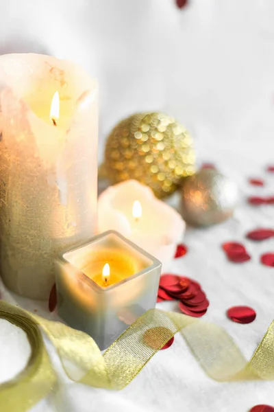 ปีใหม่และการ์ดคริสต์มาส, ทองคําที่มีสีสันและเงิน baubles กับริบบิ้น, เทียนและ confetti บนพื้นหลังสีขาว เลือกโฟกัส ท็อปวิว — ภาพถ่ายสต็อก