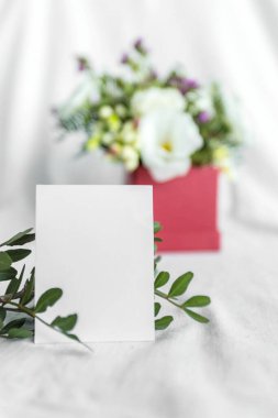 Postcard with a flowers and an empty tag for text. Romantic greeting and surprise. Concept of love, birthday, Happy mother's Day and Valentine's Day on white background. Selective focus. copy space