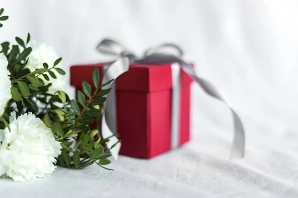 Bouquet of flowers and gift box birthday, Happy mother's Day and Valentine's day on a white textile background. Gift card. Selective focus. copy space